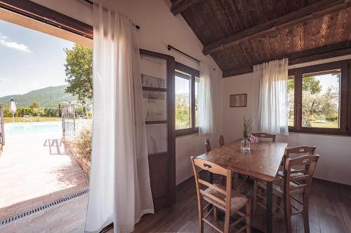 a dining room with a table and a large window at Agriturismo Querceto in Frazione Mocaiana