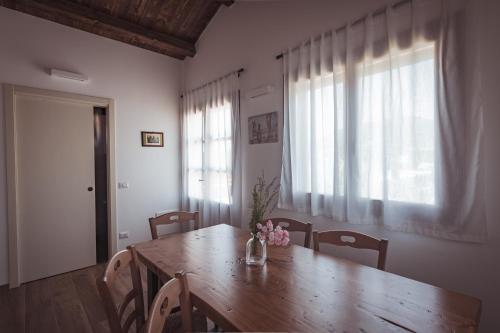 a dining room with a wooden table and windows at Agriturismo Querceto in Frazione Mocaiana