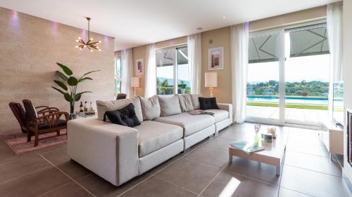 a living room with a white couch and a table at Villa Atmosfere 8, Emma Villas in Colle Alto