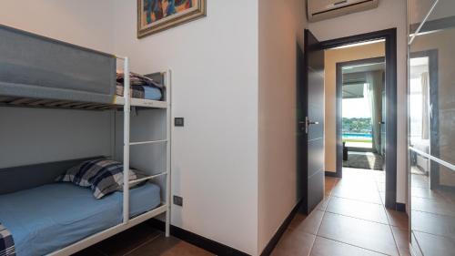 a bedroom with bunk beds and a hallway at Villa Atmosfere 8, Emma Villas in Colle Alto