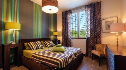a bedroom with a bed and a desk and a window at Villa Atmosfere 8, Emma Villas in Colle Alto