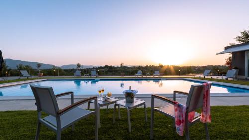 a table and two chairs in front of a swimming pool at Villa Atmosfere 8, Emma Villas in Colle Alto
