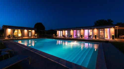 a swimming pool in front of a house at night at Villa Atmosfere 8, Emma Villas in Colle Alto