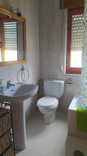 uma casa de banho com um WC branco e um lavatório. em Chalet en el Orbigo em La Bañeza