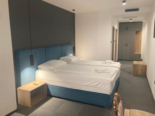 a bedroom with a large bed with white sheets at Hotel Millenium deluxe in Selce