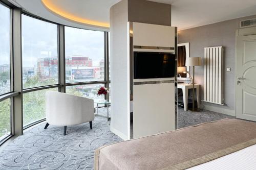 a kitchen with a refrigerator and a chair in a room with windows at The Conforium Hotel Van in Van