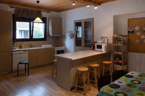 a kitchen with a counter and some stools in it at Our parent's house. Family house for rent in Skala Kallirakhis