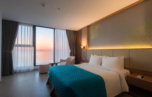 a hotel room with a bed and a view of the ocean at Navada Beach Hotel in Nha Trang