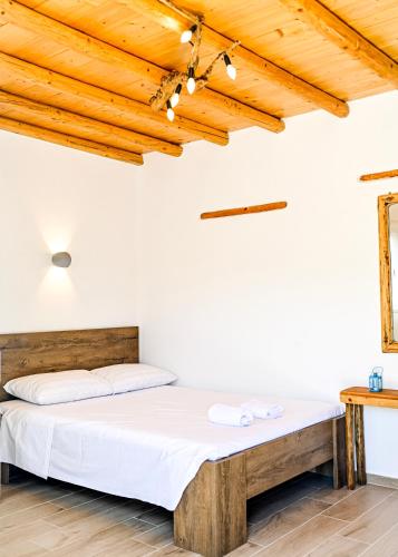 a bed in a room with a wooden ceiling at Bonzoe #2 in Parikia