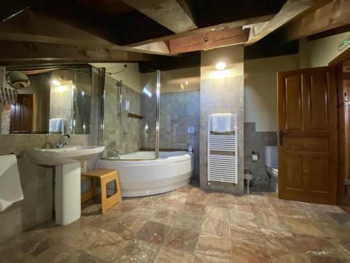 a large bathroom with a tub and a sink at La Hoja de Roble in Puebla de Sanabria