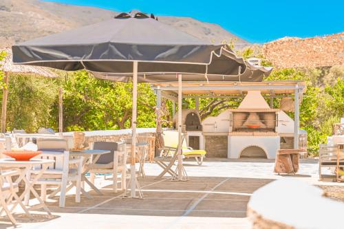 a patio with an umbrella and a pizza oven at Bonzoe #2 in Parikia