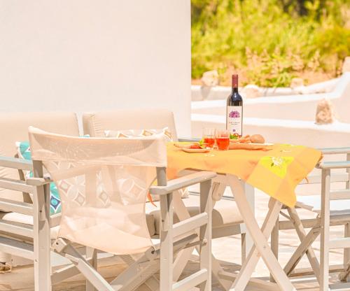 a table with a bottle of wine and two chairs at Bonzoe #2 in Parikia