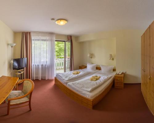 ein Hotelzimmer mit einem großen Bett und einem Fenster in der Unterkunft Pension Beck Hotel in Bad Waldsee
