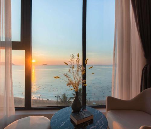 a living room with a vase on a table in front of a window at Navada Beach Hotel in Nha Trang