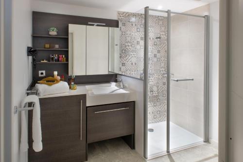 La salle de bains est pourvue d'un lavabo et d'une douche. dans l'établissement DOMITYS Les Mosaïques, à Rouen