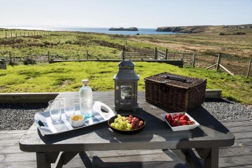 a picnic table with a bowl of fruit and a bottle at Clach Gorm in Stornoway