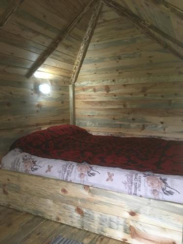 a bed in a log cabin in a room at Ambar in Nova Varoš