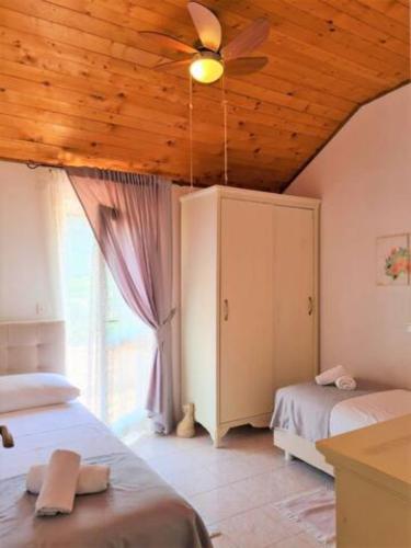 a bedroom with two beds and a ceiling fan at Villa Natura in Pitve