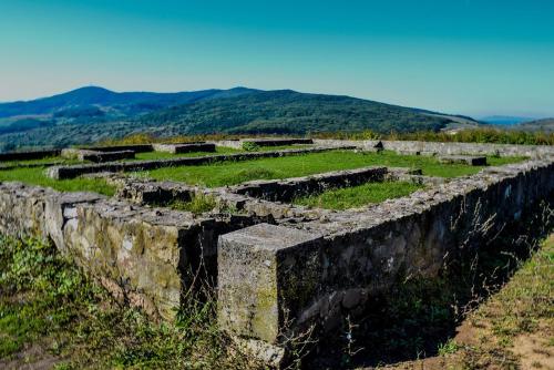 an old stone wall on a hill with mountains in the background at Vatra Strabunilor in Moigrad