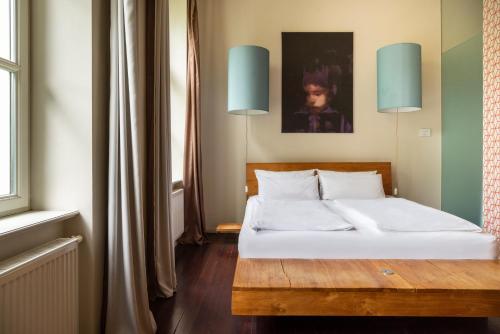 a bedroom with a bed with white sheets and blue lights at Numa Berlin Belfort in Berlin