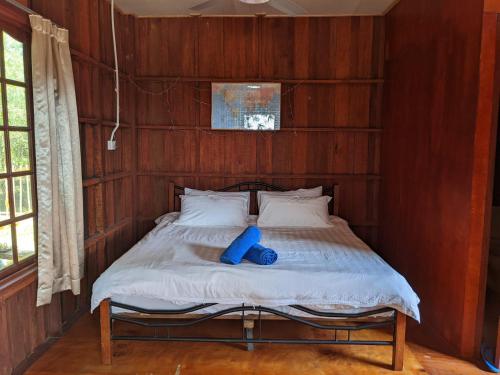 a bed in a room with a wooden wall at Betik Garden Home in Machang