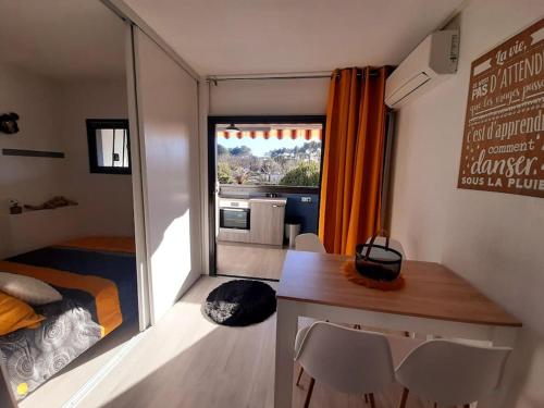 une petite pièce avec un lit, une table et des chaises dans l'établissement Appartement à Fréjus, à Fréjus