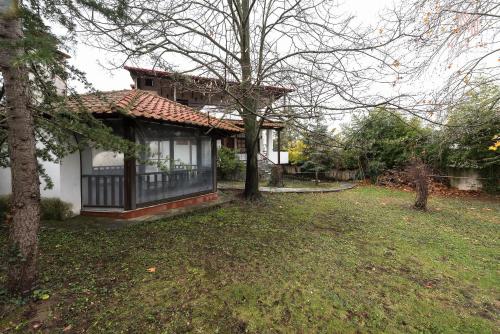 a house with a tree in front of a yard at Classico, Nilie Hospitality MGMT in Foústani