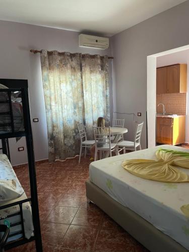 a bedroom with a bed and a table and chairs at Aragosta Shengjin 2 in Shëngjin