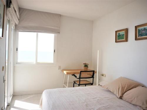 1 dormitorio con cama, escritorio y ventana en Villa Service - Barco 3º, en Calafell
