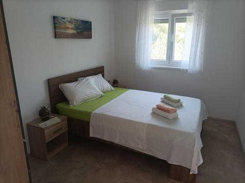 Spacious 2-bedroom apartment with terrace sea view في زابوريتش: غرفة نوم عليها سرير وفوط