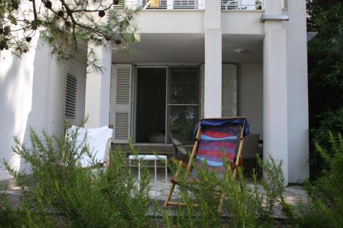 een stoel op de veranda van een huis bij Cozy Jelsa apartment in the shade of the pines. in Jelsa