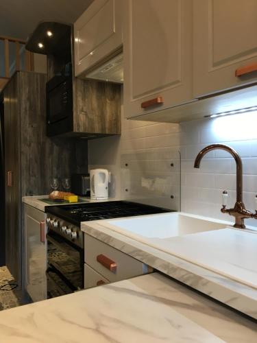 a kitchen with a sink and a stove at P57 - Riverside Family Pod with Hot Tub in Bethesda