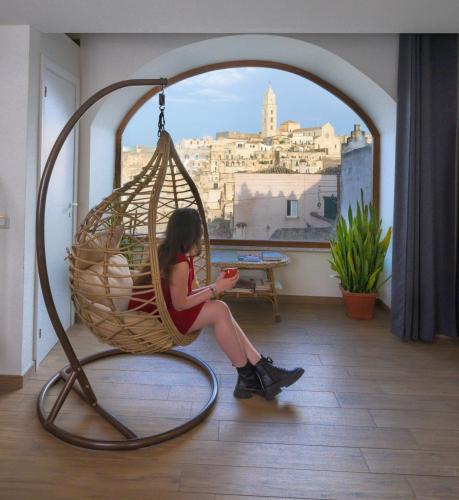 a woman sitting in a hanging chair looking at her cell phone at The View Matera in Matera