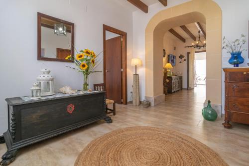 a living room with a dresser and a vase of flowers at Vila Ca Shermano in Colonia de Sant Pere