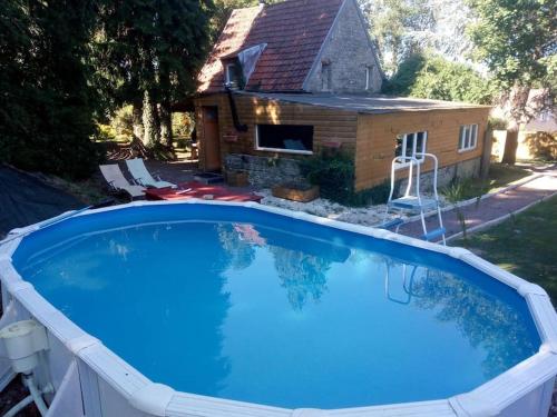 une grande piscine devant une maison dans l'établissement cottage, à Condé-sur-Noireau
