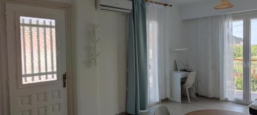 a room with a door and a desk with a computer at Meraki Skopelos in Skopelos Town