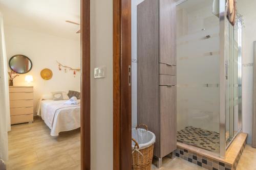 a small bedroom with a bed and a glass shower at Vila Ca Shermano in Colonia de Sant Pere
