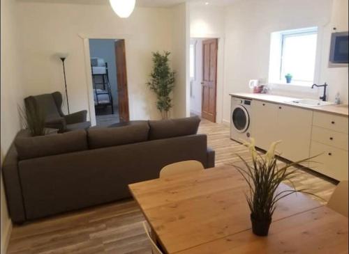 ein Wohnzimmer mit einem Sofa und einem Tisch in der Unterkunft Just Renovated Galway City Apartment in Galway