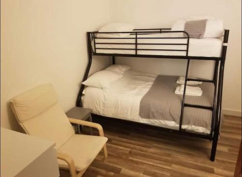 1 dormitorio con litera con silla y silla en Just Renovated Galway City Apartment, en Galway