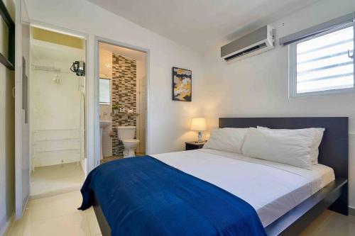 een slaapkamer met een groot bed en een badkamer bij Escape Studio Apartment Close to Agora Mall in Santo Domingo