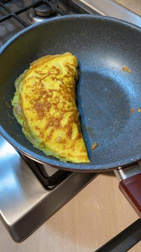 an omelet frying in a pan on a stove at O Mie de Lacuri in Vrata