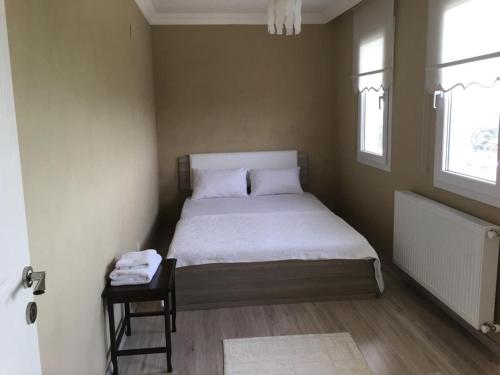 a small bedroom with a bed and a side table at Doğadaki Eviniz in Dernek