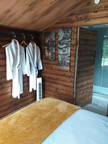 Delightful cosy cabin في مارغايْت: غرفة نوم بجدران خشبية وسرير بمناشف