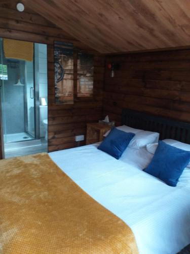 a bedroom with two beds with blue pillows at Delightful cosy cabin in Margate