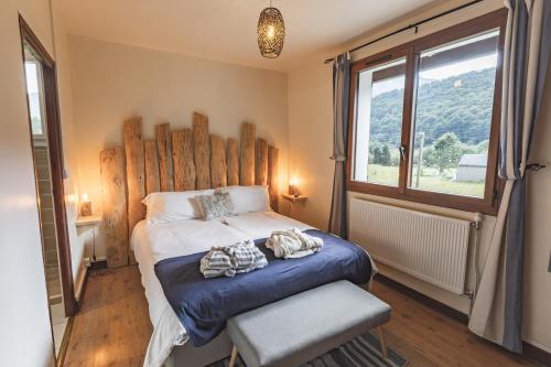 Chalet Ouréa في كامبان: غرفة نوم مع سرير مع اللوح الأمامي الخشبي ونافذة
