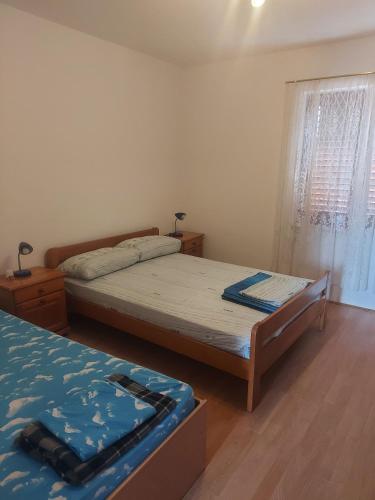 a bedroom with two beds and a window at Apartments Vilanija in Vilanija