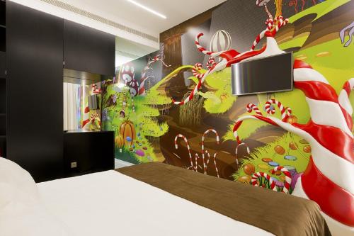 1 dormitorio con 1 cama y una pared colorida en Hotel Fabrica do Chocolate, en Viana do Castelo