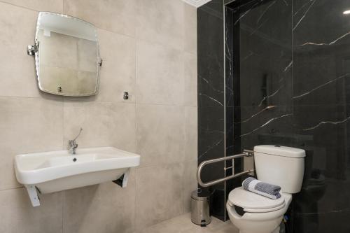a bathroom with a sink and a toilet and a mirror at Kallistefan in Kissamos