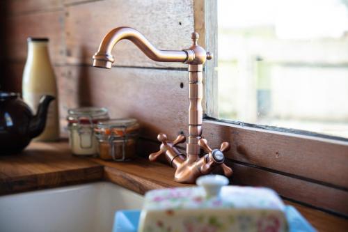 a kitchen sink with a faucet next to a window at The Hoot Romantic Glamping in Southwick