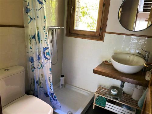 een badkamer met een wastafel, een toilet en een spiegel bij Casa con impresionantes vistas en Martinet in Martinet